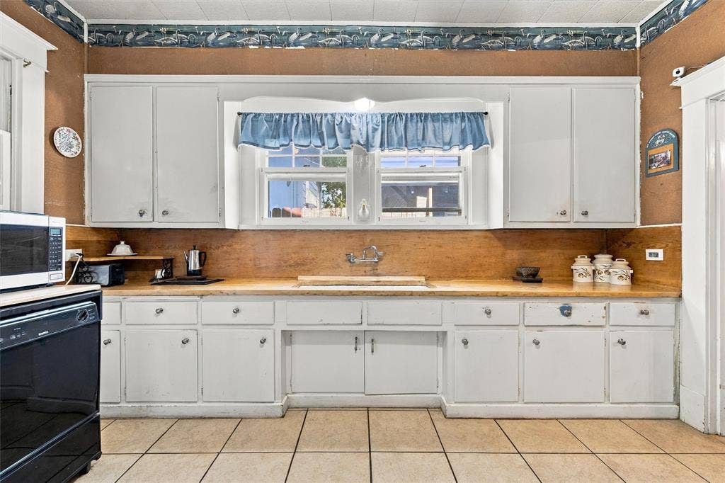2725 Morrow Avenue, Waco, TX 76707 White cabinetry with ample storage, wood-finish countertops, and a double-basin sink