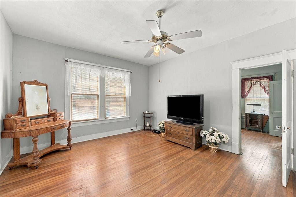 2725 Morrow Avenue, Waco, TX 76707 Wood-finish flooring, light gray wall paint, white trim, dual windows, and a ceiling fan with integrated lighting
