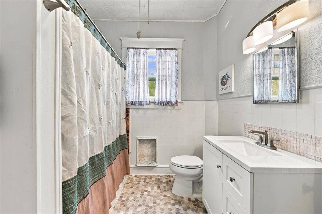 2725 Morrow Avenue, Waco, TX 76707 White vanity with integrated sink, mosaic tile backsplash, and hexagonal floor tiling