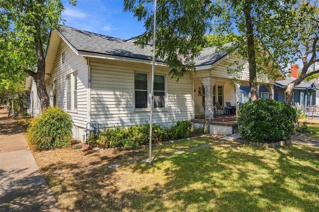 2725 Morrow Avenue, Waco, TX 76707 White siding exterior with a covered front porch, a gabled roof, and established landscaping