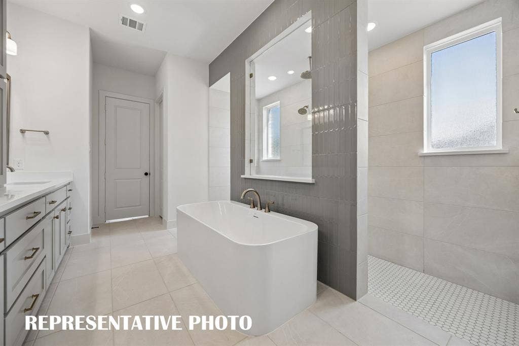 Featuring our signature walk through shower with free standing tub, you will enjoy a spa like experience every day in this wonderful owner's bath.  REPRESENTATIVE PHOTO