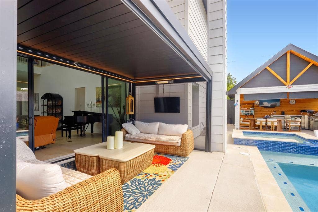 3950 Beechwood Lane, Dallas, TX 75220 Expansive concrete patio with a full outdoor kitchen, built-in swimming pool, and dedicated spa