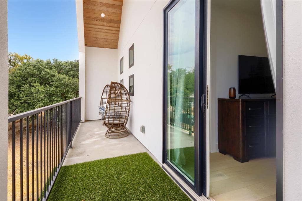 3950 Beechwood Lane, Dallas, TX 75220 Balcony featuring a black metal railing, concrete flooring, and a wood-finish ceiling