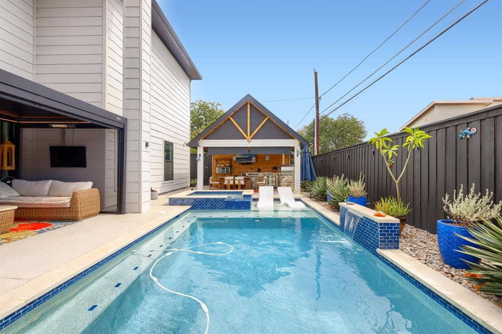 3950 Beechwood Lane, Dallas, TX 75220 Rectangular swimming pool with integrated spa and water feature, complemented by a dedicated outdoor living structure