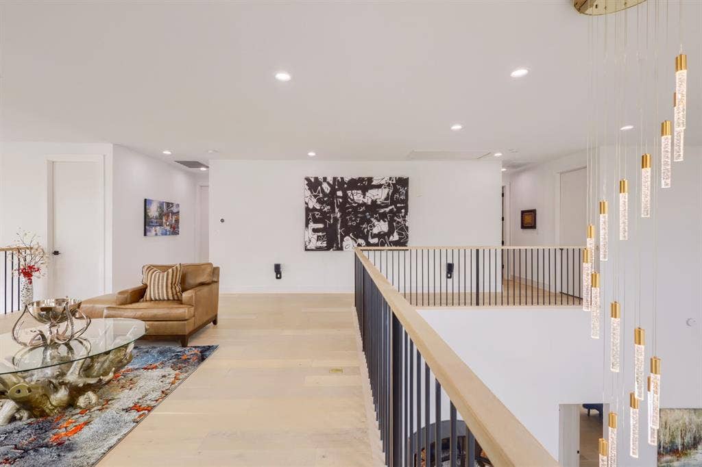 3950 Beechwood Lane, Dallas, TX 75220 Open concept upper level featuring light wood-finish flooring, recessed lighting, a modern railing with vertical balusters, and a contemporary chandelier with multiple hanging pendants