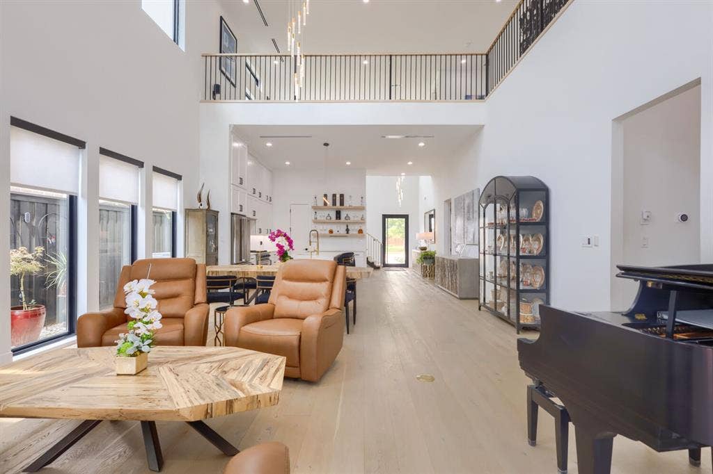 3950 Beechwood Lane, Dallas, TX 75220 Two-story living space with a mezzanine balcony, recessed lighting, wood-finish flooring, and a contemporary chandelier