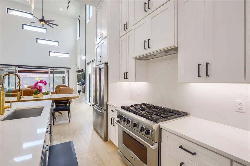 3950 Beechwood Lane, Dallas, TX 75220 Gourmet kitchen with stainless steel range, white cabinetry, and light-toned countertops