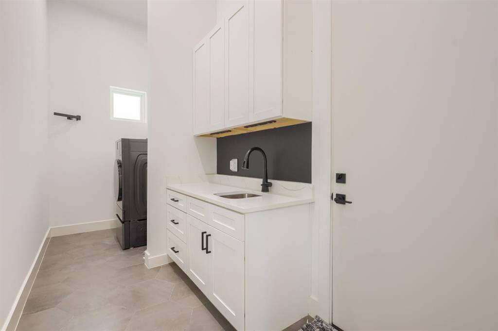 3950 Beechwood Lane, Dallas, TX 75220 Laundry area featuring white cabinetry, a sink with a matte black gooseneck faucet, light-toned countertop, and hexagonal floor tiling