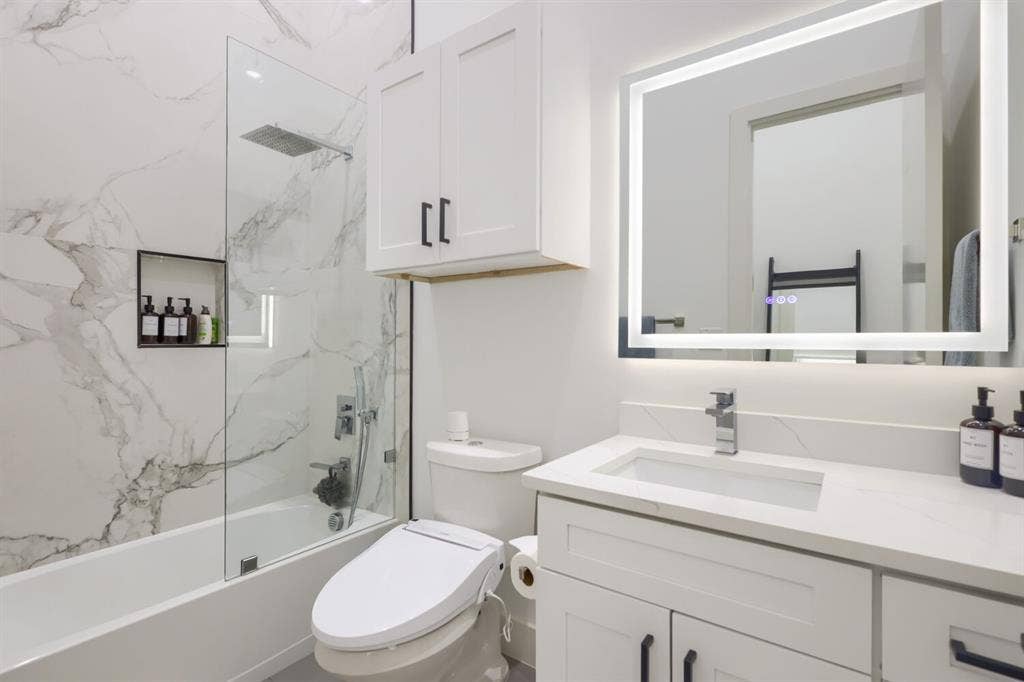 3950 Beechwood Lane, Dallas, TX 75220 White vanity with quartz countertop, undermount sink, and illuminated mirror