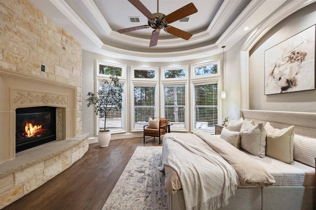 Primary bedroom with fireplace and pool views.