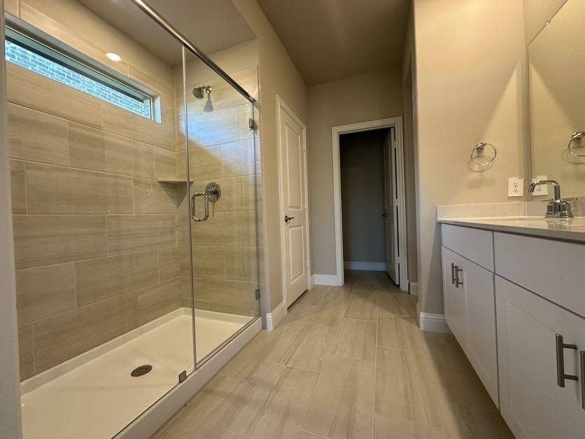 Spacious bathroom featuring a glass-enclosed shower with tile surround, a built-in shower niche, and a transom window