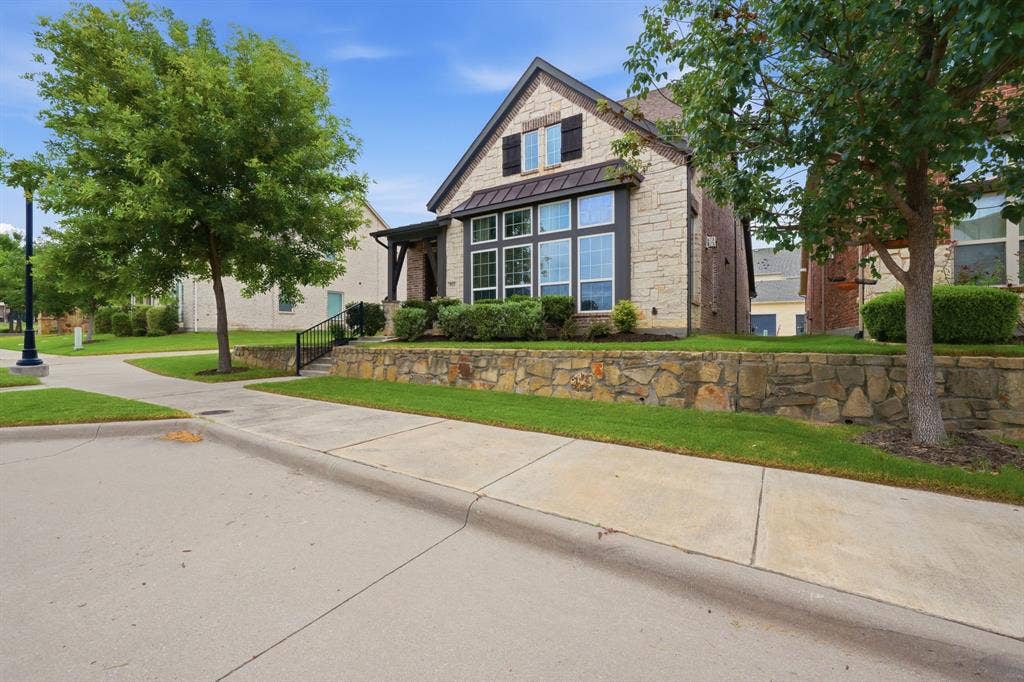911 Midland Drive, Allen, TX 75013 Stone facade with dark trim accents, featuring a prominent bay window