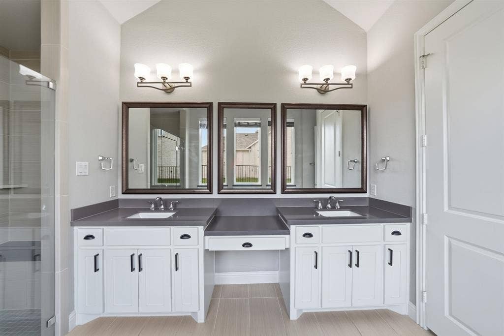 911 Midland Drive, Allen, TX 75013 Dual vanities with undermount sinks, flanked by white cabinetry and dark countertops