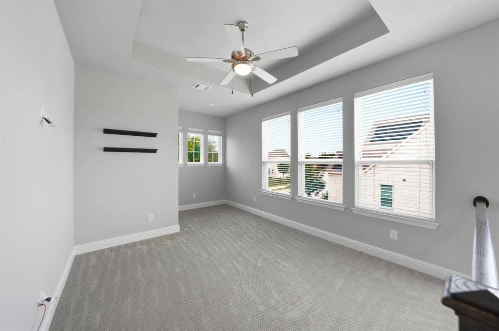 911 Midland Drive, Allen, TX 75013 Tray ceiling, flush-mount ceiling fan, multiple windows with blinds, gray carpeting, and white baseboards