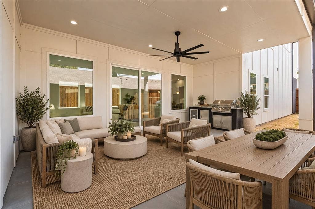 Covered outdoor patio featuring a built-in grill station, ceiling fan, recessed lighting, and large sliding glass doors