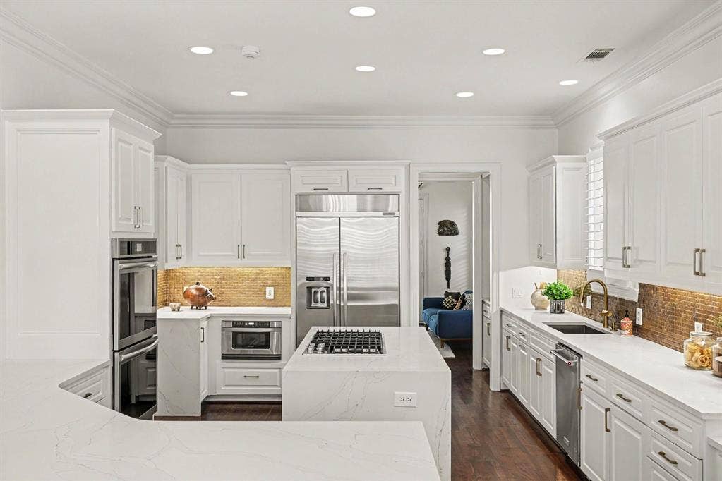 5542 Monticello Avenue, Dallas, TX 75206 Gourmet kitchen with white cabinetry, stainless steel appliances, white countertops, a central island with a gas cooktop, and hardwood flooring