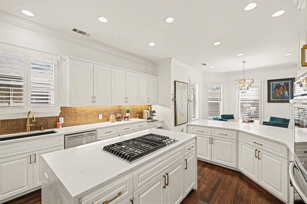 5542 Monticello Avenue, Dallas, TX 75206 Kitchen featuring white shaker-style cabinetry, a built-in gas range, stainless steel appliances, and a curved island with countertop seating