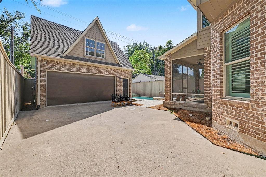 5542 Monticello Avenue, Dallas, TX 75206 Detached brick garage with an overhead door, wood siding, and an attic window