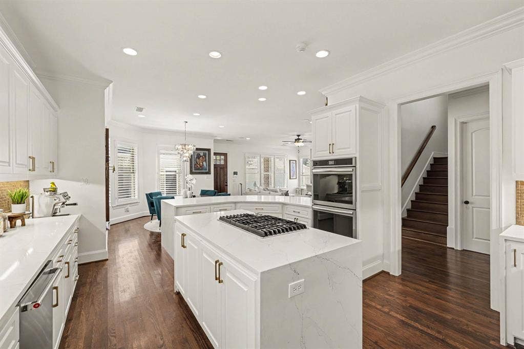 5542 Monticello Avenue, Dallas, TX 75206 Gourmet kitchen featuring white cabinetry, integrated stainless steel appliances, and a gas cooktop on a center island
