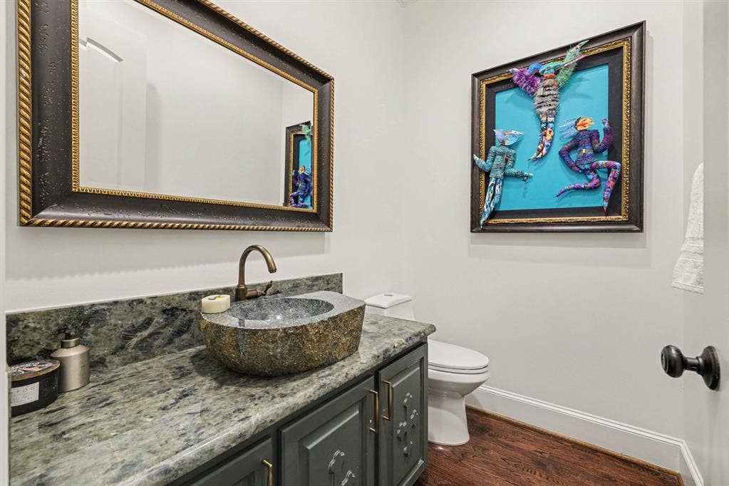 5542 Monticello Avenue, Dallas, TX 75206 Stone vessel sink with a bronze-finish faucet, set atop a patterned stone countertop