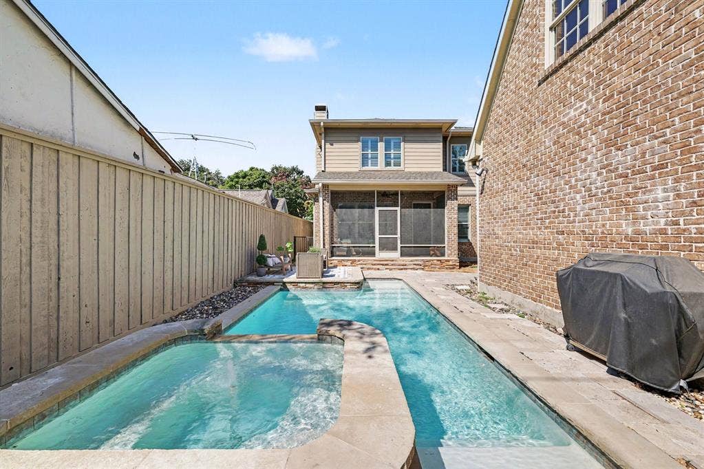 5542 Monticello Avenue, Dallas, TX 75206 Backyard featuring a rectangular swimming pool, integrated spa, stone coping, privacy fencing, and a screened porch