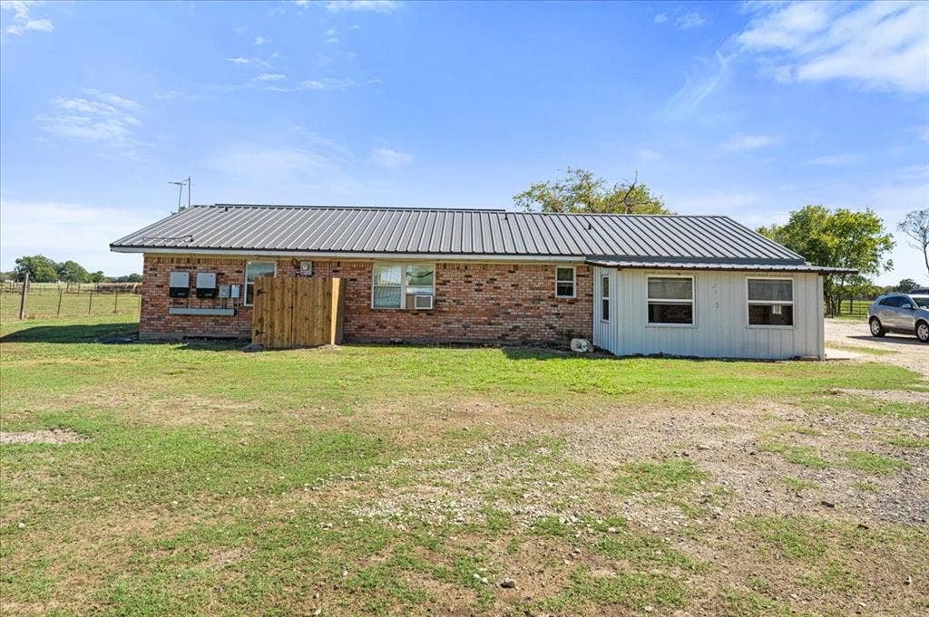 Brick exterior with a metal roof and an attached white-sided addition