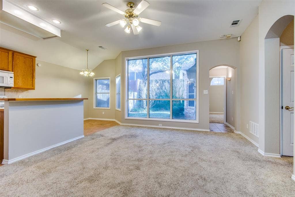 1913 Piney Creek Boulevard, Denton, TX 76205 Vaulted ceilings, large picture windows, arched doorways, ceiling fan, and built-in kitchen cabinetry