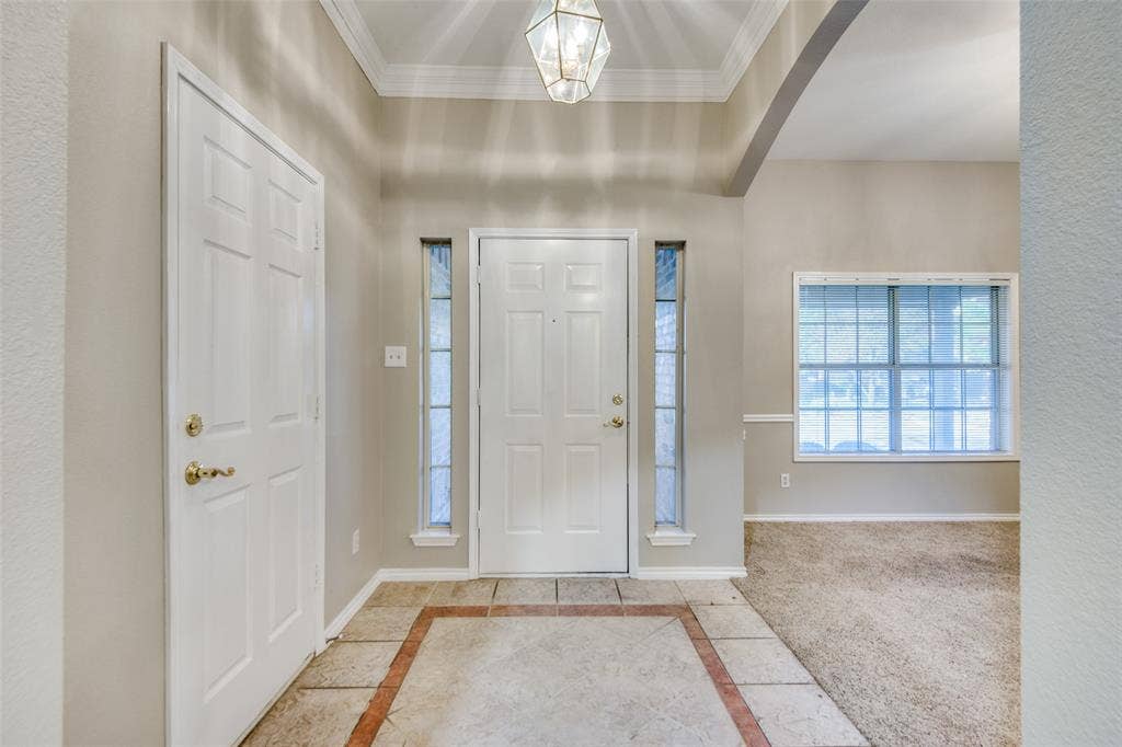 1913 Piney Creek Boulevard, Denton, TX 76205 Entryway featuring a decorative ceiling light, tiled flooring with an accent border, and a transom window above the front door