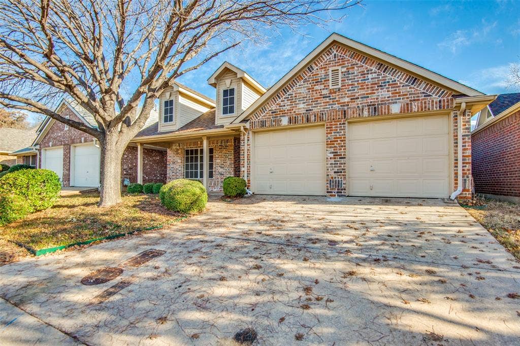 1913 Piney Creek Boulevard, Denton, TX 76205 Brick exterior with dormer windows, a covered entry, and a two-car garage