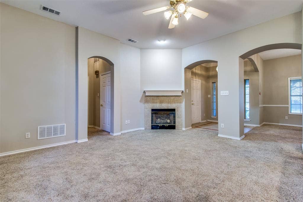 1913 Piney Creek Boulevard, Denton, TX 76205 Carpeted living area with a built-in fireplace, tile surround, and mantel