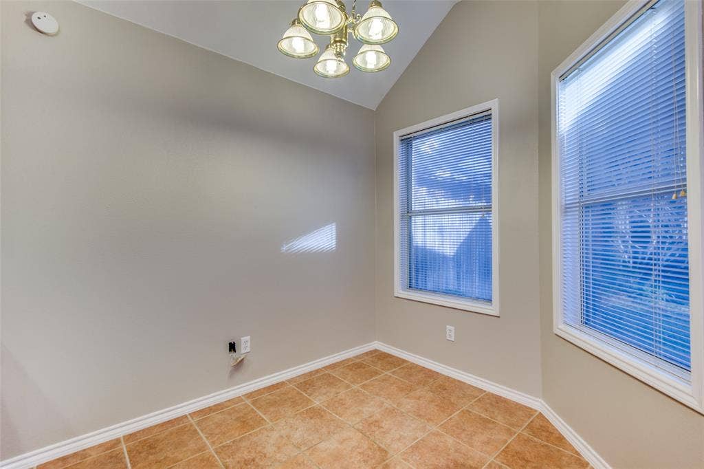 1913 Piney Creek Boulevard, Denton, TX 76205 Angled ceiling with a five-light chandelier, two windows with blinds, and tile flooring