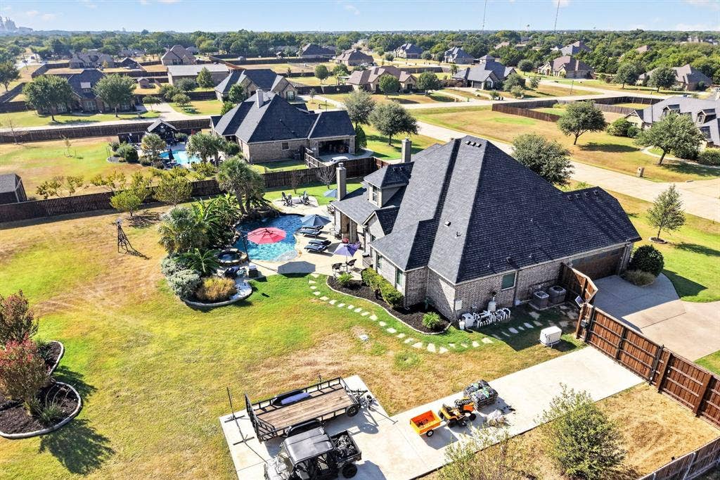 5020 Lindy Court, Midlothian, TX 76065 Brick exterior property with multi-peak roofline, concrete driveway, and privacy fencing