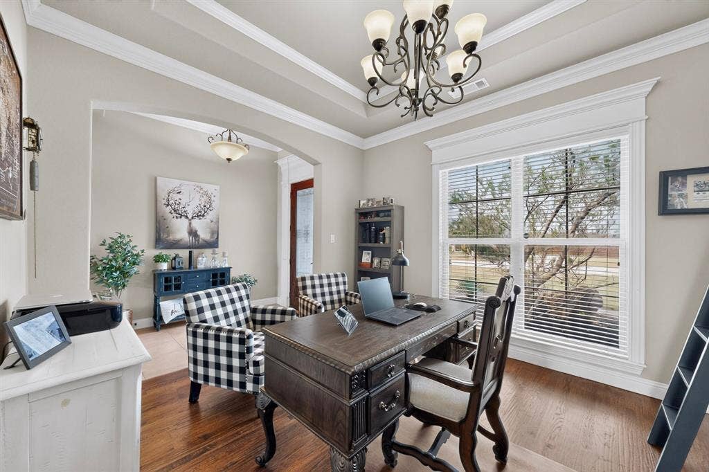 5020 Lindy Court, Midlothian, TX 76065 Hardwood-finish flooring, recessed tray ceiling with crown molding, decorative chandelier, arched entryway, and large windows with blinds