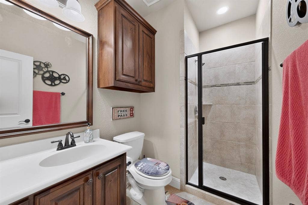 5020 Lindy Court, Midlothian, TX 76065 Vanity with dark wood cabinetry, white countertop, and framed mirror