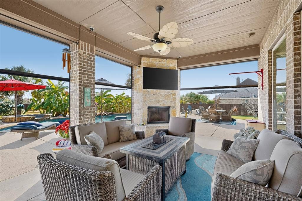 5020 Lindy Court, Midlothian, TX 76065 Covered patio with brick and stone accents, a built-in fireplace, and a ceiling fan