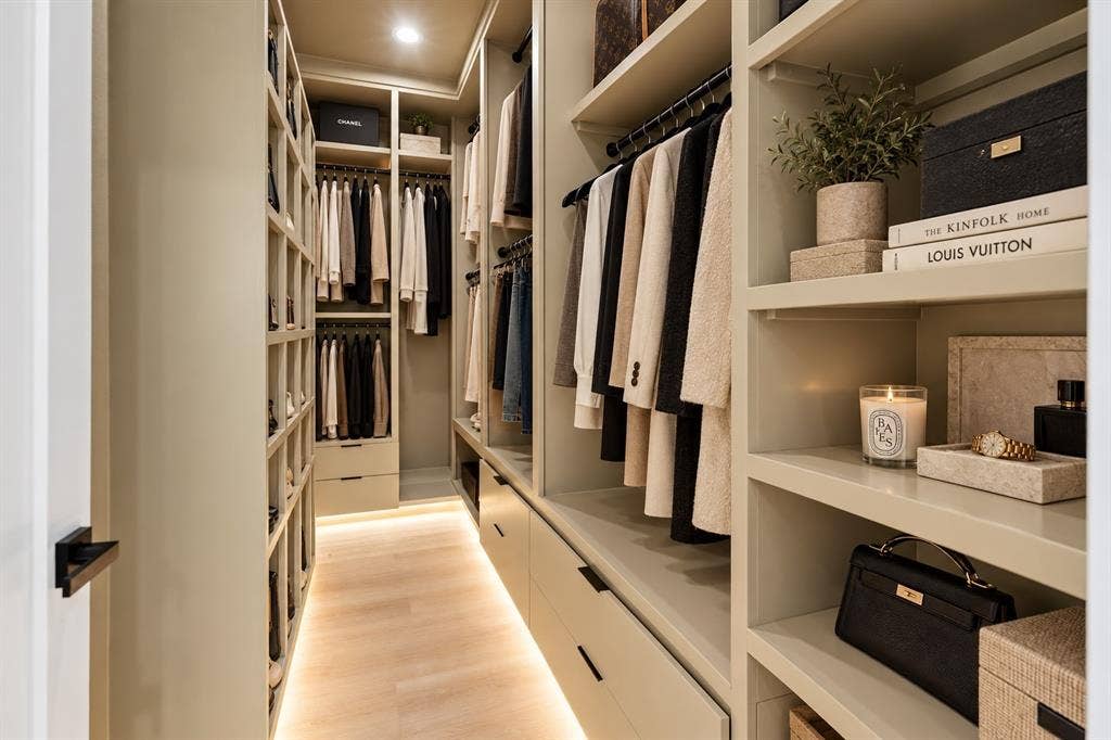 1503 Dennison Street, Dallas, TX 75212 Custom closet system with integrated shelving, hanging rods, recessed lighting, and wood-finish flooring with accent lighting
