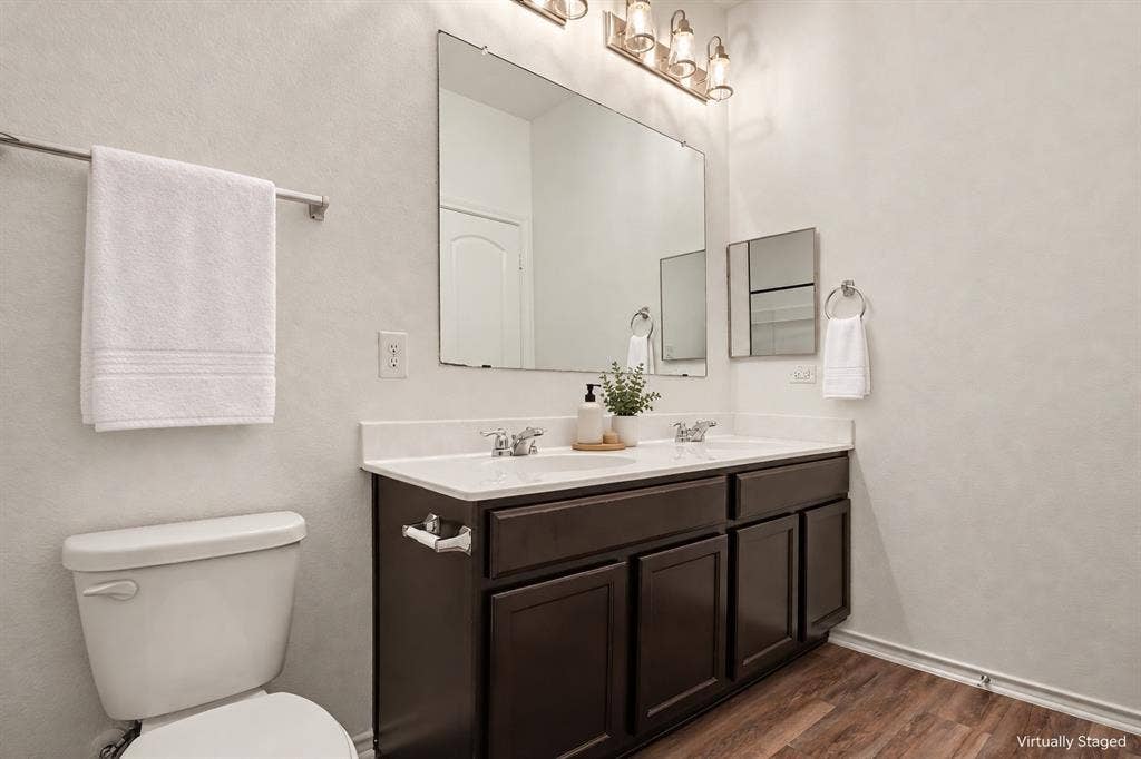257 Michelle Drive, Grand Prairie, TX 75051 Virtually staged with decorative accessories. This bathroom features a double vanity, generous mirror and cabinet storage.