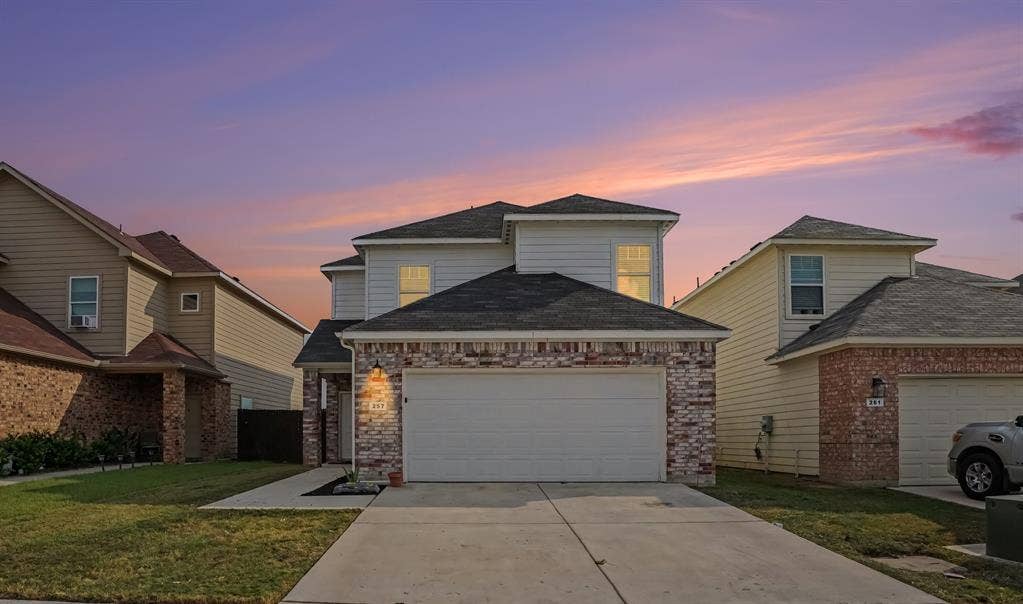 257 Michelle Drive, Grand Prairie, TX 75051 Twilight view of the home with a two-car garage and a welcoming front approach.