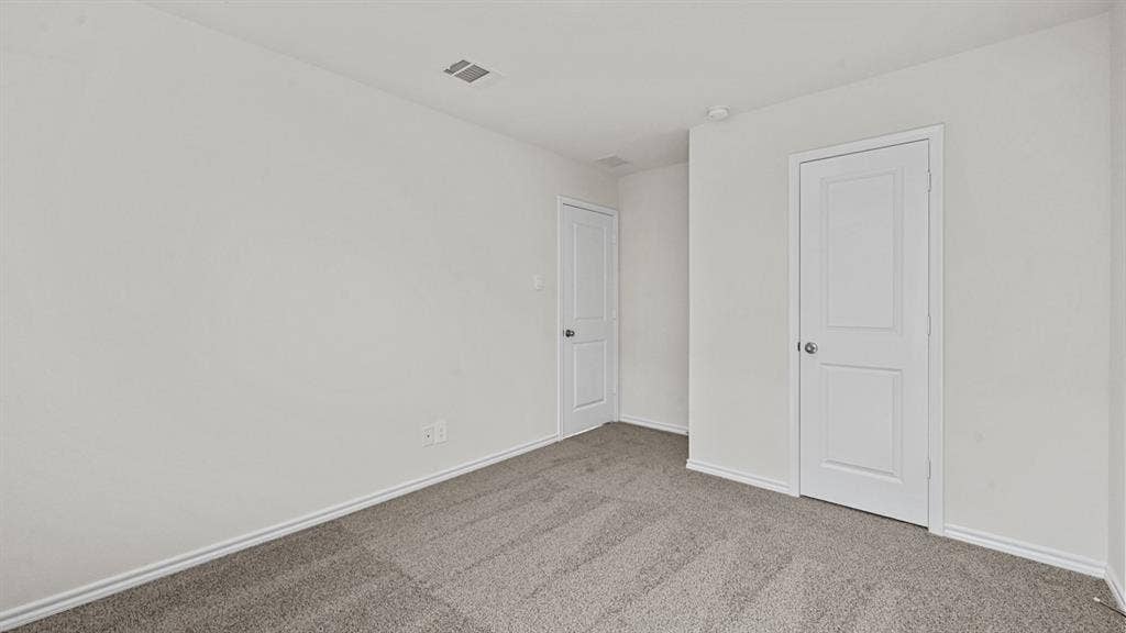 Neutral wall color, grey carpet, and two paneled doors with chrome hardware