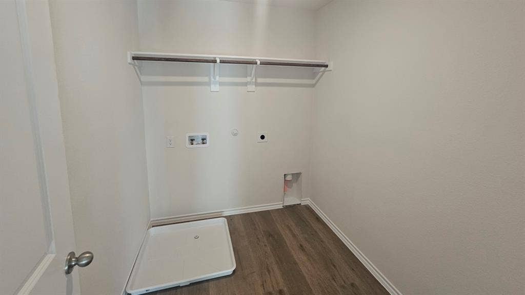 Dedicated utility space featuring wood-finish flooring, white baseboards, and light neutral wall paint