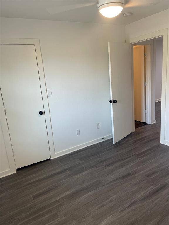 321 E 8th Street, #203, Dallas, TX 75203 Wood-finish flooring with white walls and trim, featuring a ceiling fan with integrated lighting