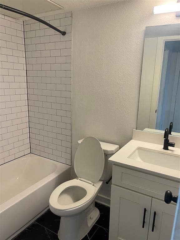 321 E 8th Street, #203, Dallas, TX 75203 White subway tile shower surround, black-finish fixtures, white vanity cabinet, white countertop, and dark floor tiling