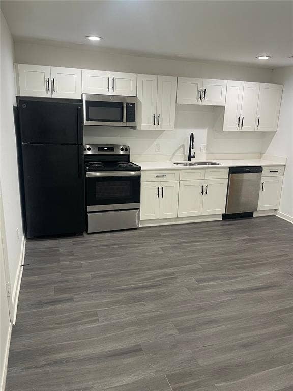 321 E 8th Street, #203, Dallas, TX 75203 Kitchen featuring white shaker cabinetry, stainless steel appliances, a black refrigerator, light-toned countertops, and wood-finish flooring