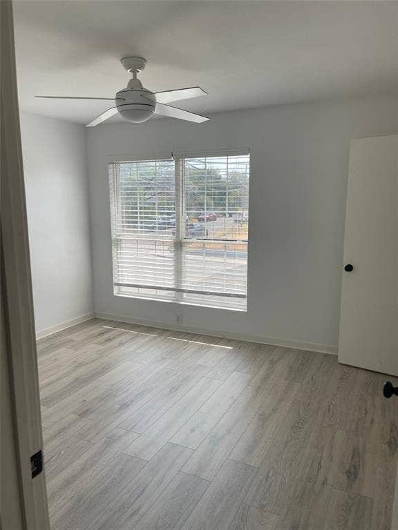 321 E 8th Street, #218, Dallas, TX 75203 White ceiling fan, window with blinds, wood-finish flooring, and white interior walls