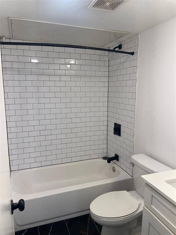 321 E 8th Street, #218, Dallas, TX 75203 Bathtub with subway tile surround, black matte fixtures, and black tile flooring