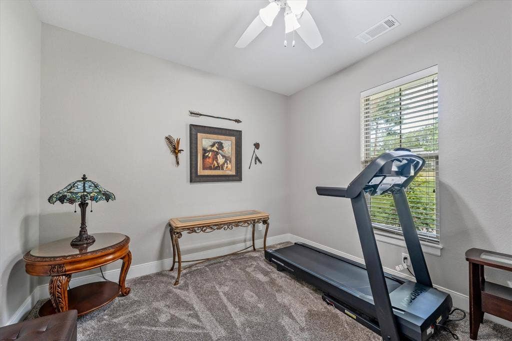 14486 Meadow Glen, Lindale, TX 75771 Carpeted room featuring a window with blinds, a ceiling fan, and light gray wall paint