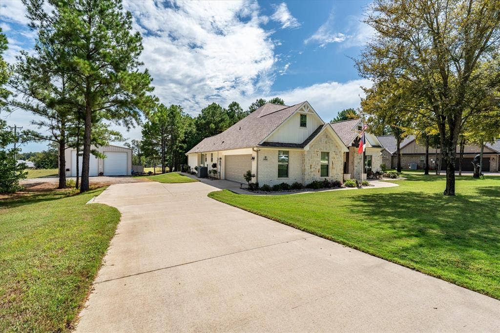 14486 Meadow Glen, Lindale, TX 75771 Exterior featuring stone and siding finishes, gabled rooflines, an attached garage, and a concrete driveway
