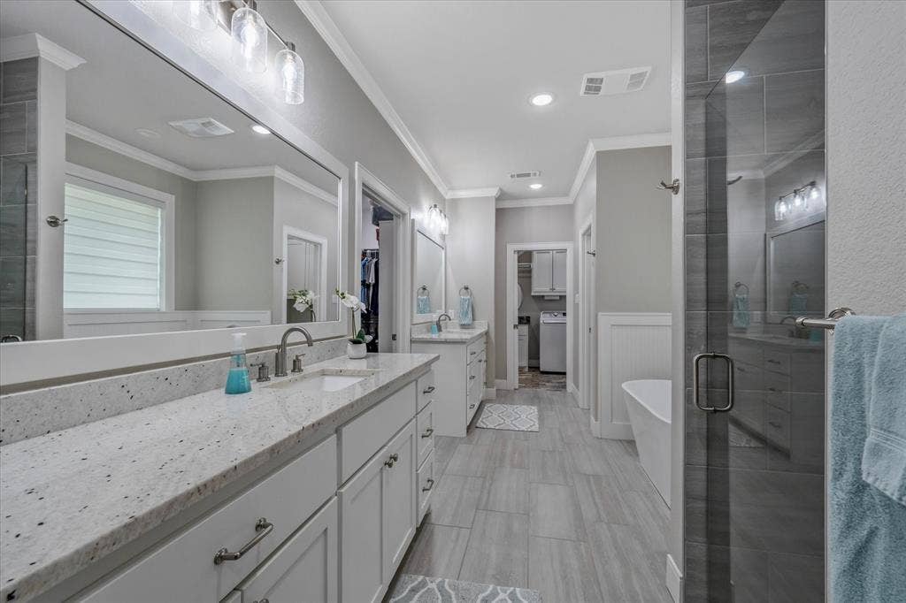 14486 Meadow Glen, Lindale, TX 75771 Expansive vanity with a light-toned countertop, dual sinks, and ample storage cabinetry