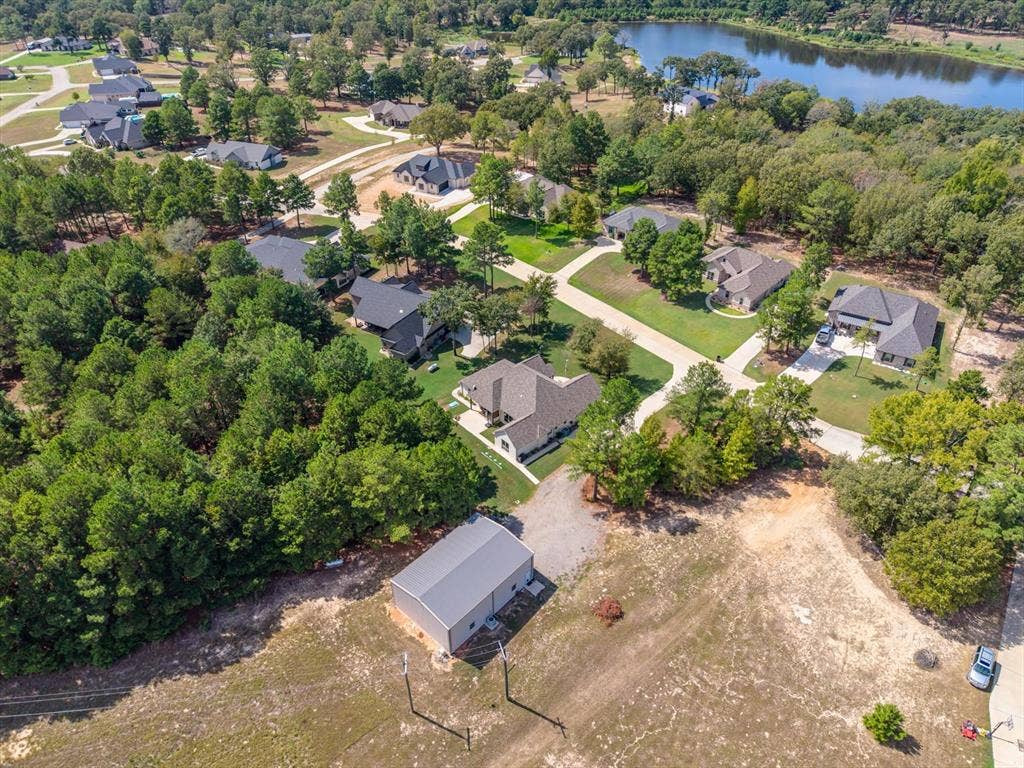 14486 Meadow Glen, Lindale, TX 75771 Expansive lot featuring a standalone metal building, surrounded by mature trees and a paved driveway