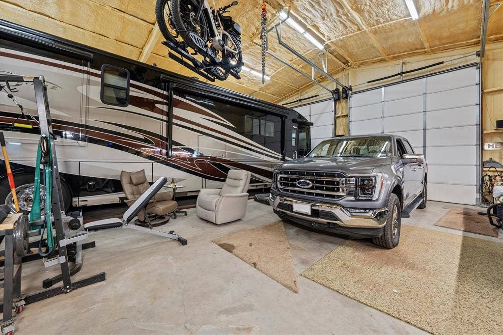 14486 Meadow Glen, Lindale, TX 75771 High ceilings with exposed insulation, concrete flooring, and multiple overhead doors